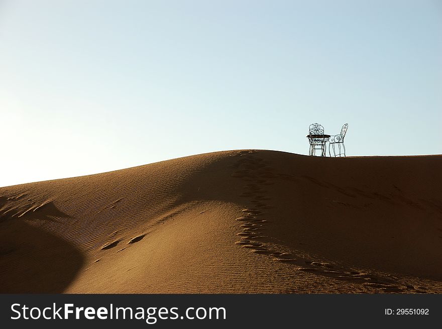 Wrought Iron Table And Chairs On The Top Of Sand Dune