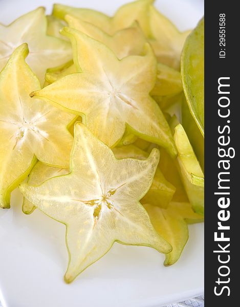 Close up fresh starfruit sliced on white plate