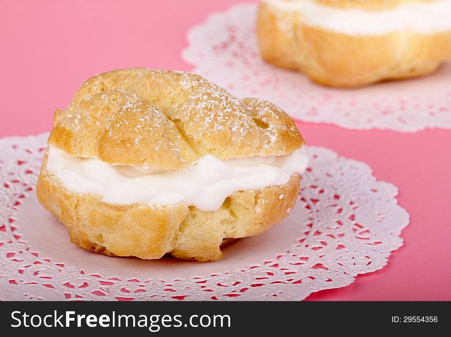 Cream puff pastry on a pink table