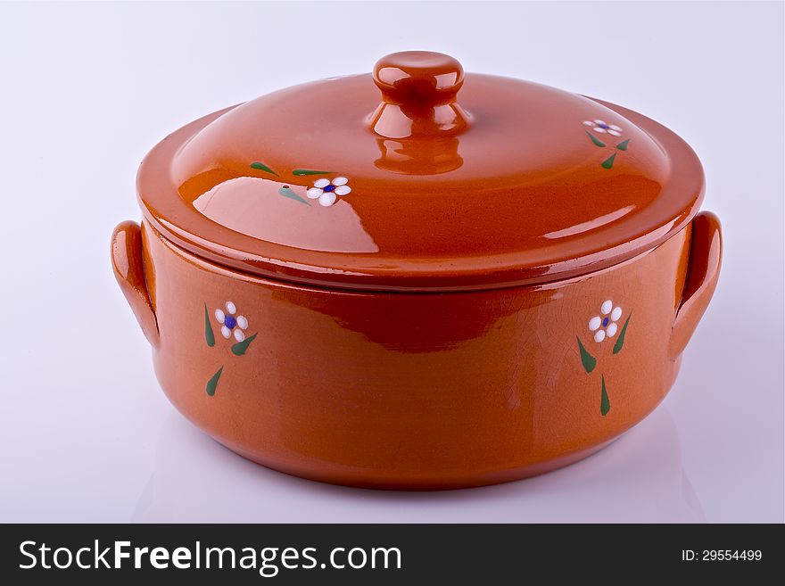 Orange ceramic clay pot with lid on a light background