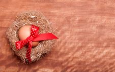 Egg Swollen By A Red Bow Lies In The Nest Royalty Free Stock Images Egg Swollen By A Red Bow Lies In The Nest Royalty Free Stock Images