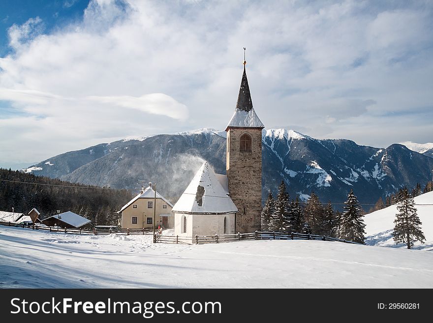 A Wintertime View Of A Small Church With A Tall Steeple