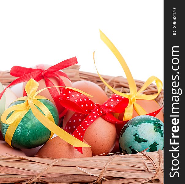 Easter eggs in a straw basket on the white