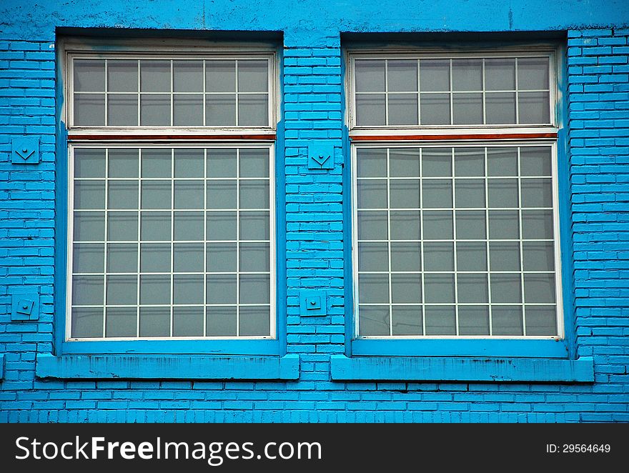 Two windows in old blue brick wall. Two windows in old blue brick wall