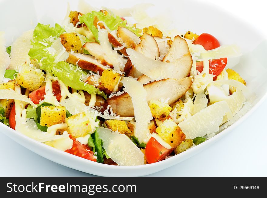 Caesar Salad with Garlic Crouton, Romaine Lettuce, Cherry Tomato, Eggs, Sauce and Grated Parmesan Cheese and Arrangement of Grilled Chicken Breast closeup in White Bowl