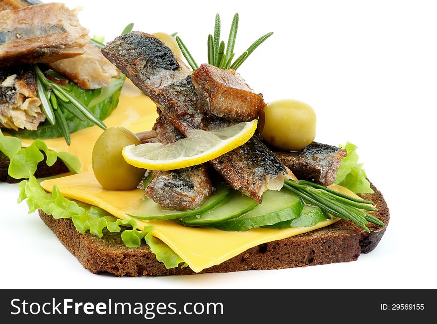 Sandwiches with Smoked Sardines, Cucumber, Cheese, Green Olive, Lettuce and Whole Wheat Bread closeup on white background. Sandwiches with Smoked Sardines, Cucumber, Cheese, Green Olive, Lettuce and Whole Wheat Bread closeup on white background