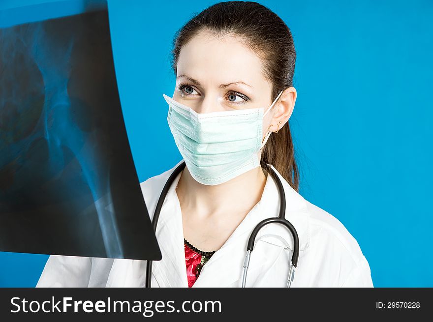 Young doctor in a mask holds X-ray