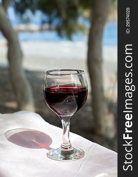 Glass of red wine on the background of the sea
