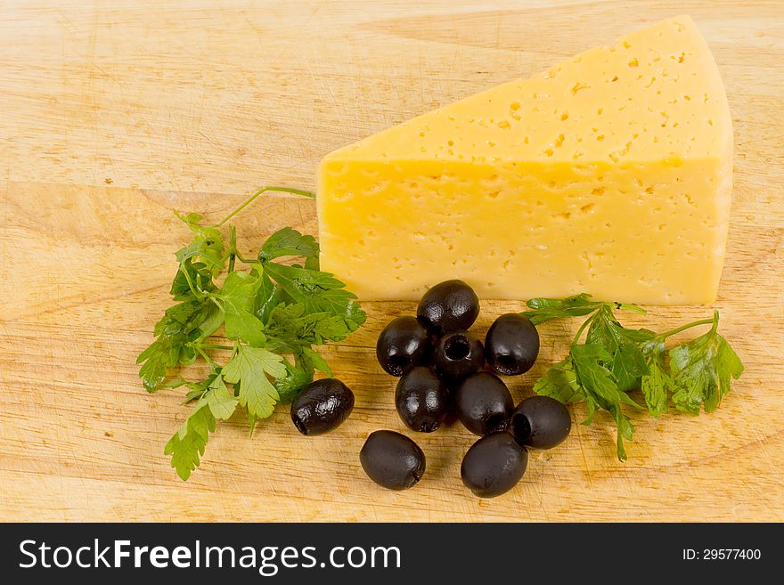 Black olives and piece of cheese on kitchen table. Black olives and piece of cheese on kitchen table