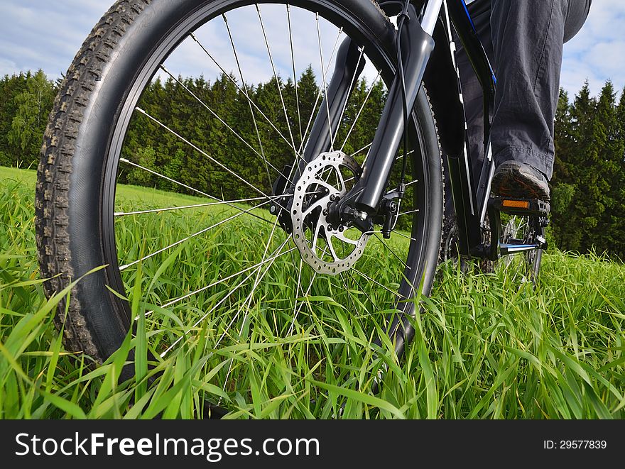 Bicyclist riding a mountain bike in countryside. Shallow depth of field.