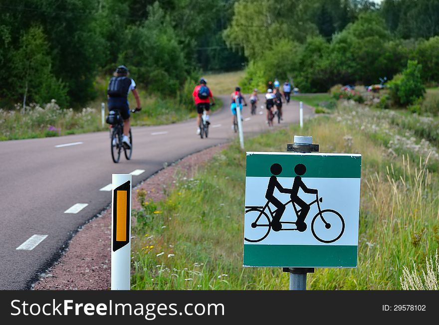 Cyclists on the road and traffic sign