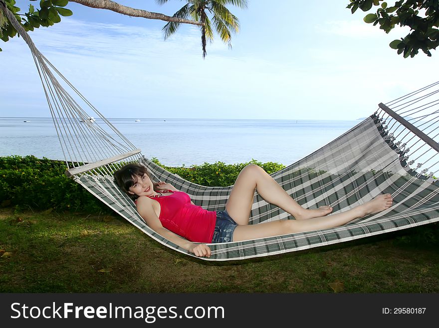 Woman relaxing on hammock  near the ocean