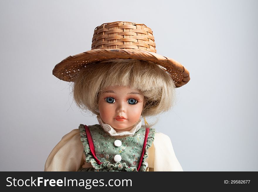 Photo the doll on a light background . Pretty doll in the antique dress