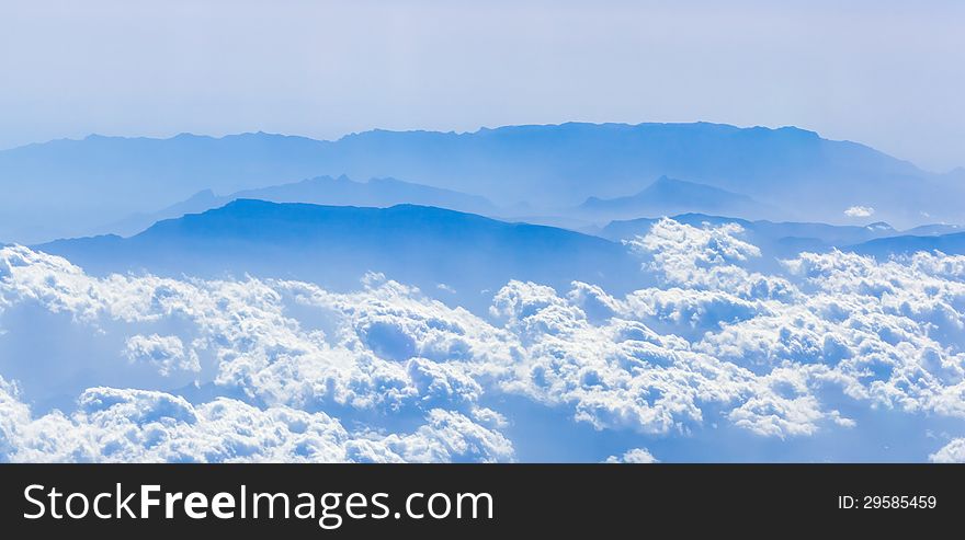 Clouds and mountains from a height, the view from the airplane window. Clouds and mountains from a height, the view from the airplane window