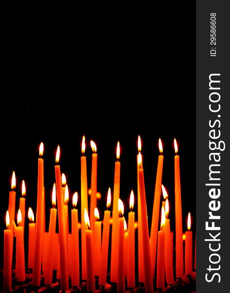 Group of burning candles on black background