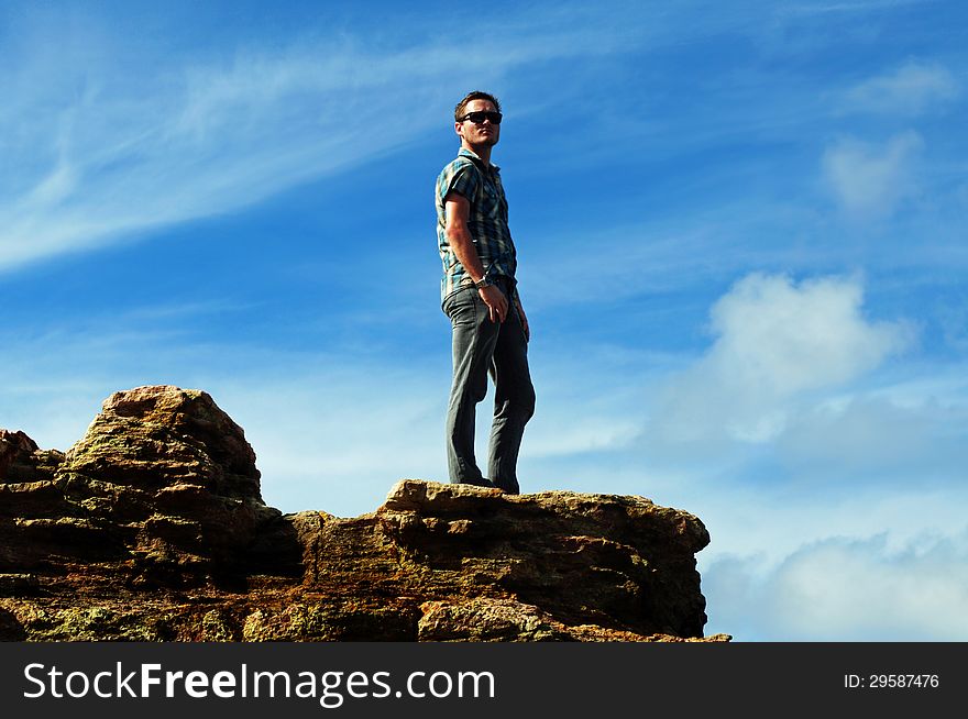 A dramatic photograph of a handsome young man standing alone on the edge of a high cliff face overlooking the ocean. Photo was taken at Point Lookout in Stradbroke Island, Queensland, Australia which is only a short ferry ride from Brisbane city. A dramatic photograph of a handsome young man standing alone on the edge of a high cliff face overlooking the ocean. Photo was taken at Point Lookout in Stradbroke Island, Queensland, Australia which is only a short ferry ride from Brisbane city.