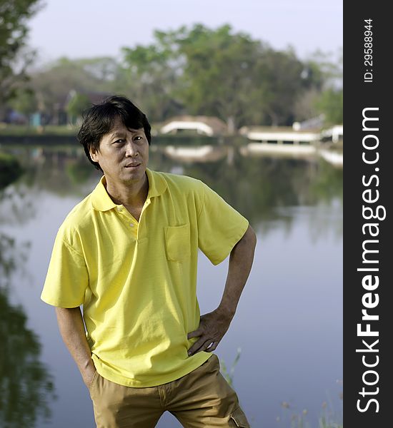 A portrait of a senior south asian man by lake. A portrait of a senior south asian man by lake