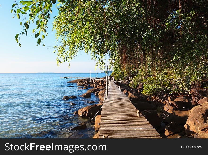 Wooden bridge among the rocks along the seashore. Beautiful sea landscape.