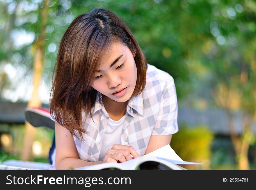 Beautiful young asian student is reading