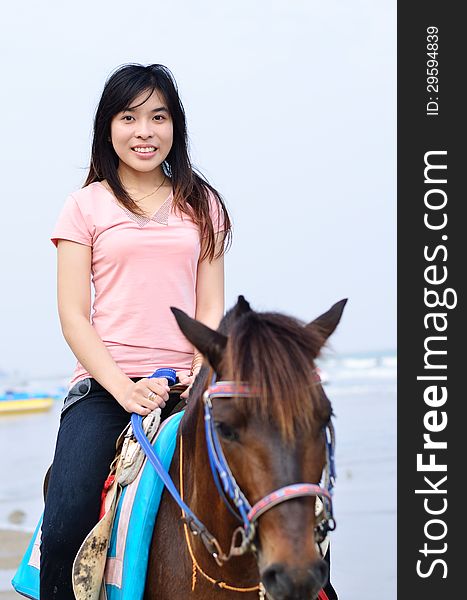 Beautiful asian woman with brown horse on beach
