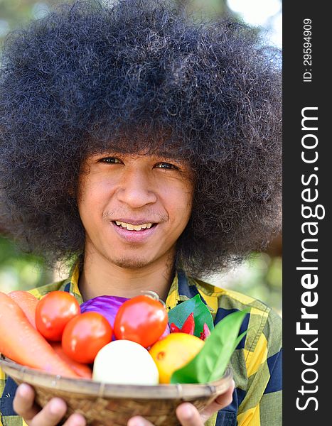 Man Holing Bucket Of Colourful Vegetables