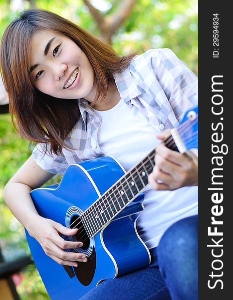 Beautiful Asian Woman Holding Guitar