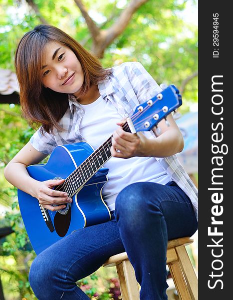 Beautiful Asian Woman Holding Guitar