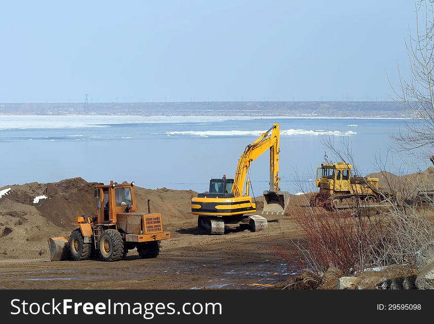 Excavation tractors on the river in the spring. Excavation tractors on the river in the spring