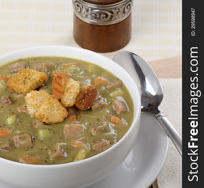 Bowl of ham and pea soup with carrots and celery