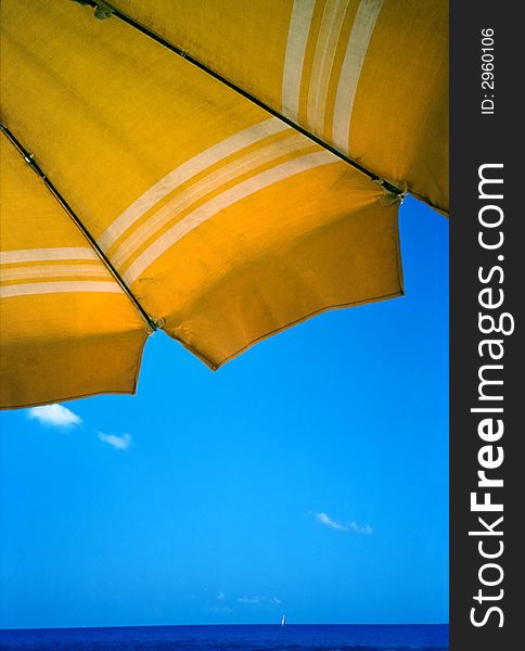 Yellow umbrella against clear blue summer sky