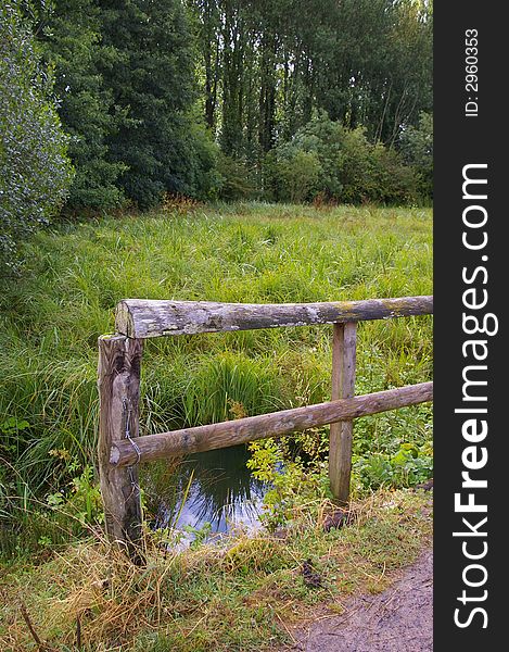 Wooden fence along a marsh (with reflection in water). Wooden fence along a marsh (with reflection in water).