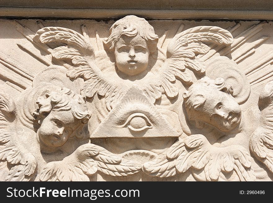 Bas-relief with the heads of three angels and a eye in the middle of a triangle. Bas-relief with the heads of three angels and a eye in the middle of a triangle