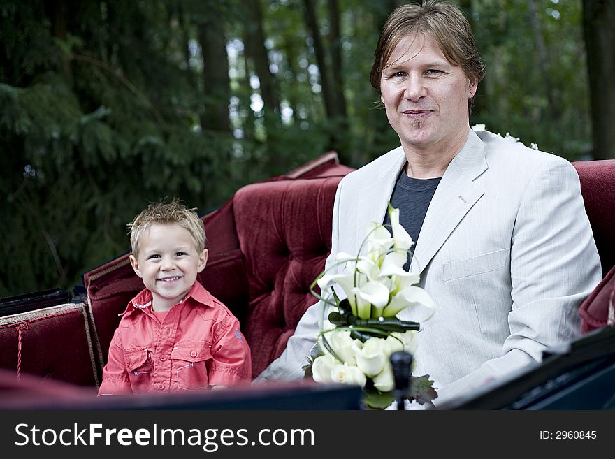 Father and son posing in bridal coach on route to the bride. Father and son posing in bridal coach on route to the bride.