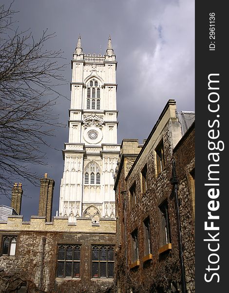 Image of the whit tower of westminister abbey set against the darkening rain clouds behind.