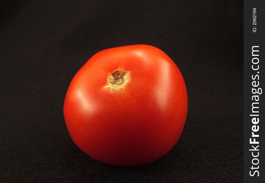 Fresh tomato on black background