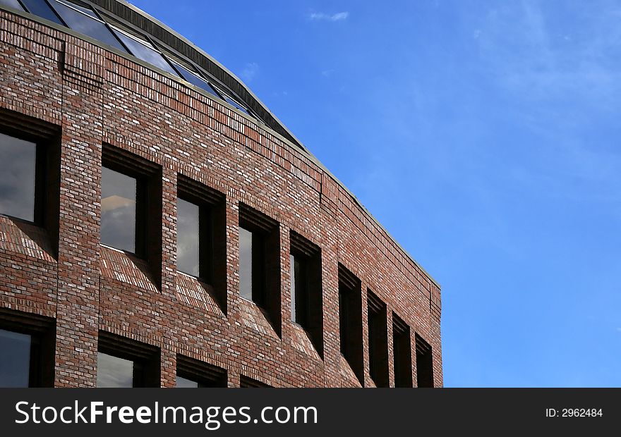 Majestic yet simple curved brick building  against a light blue sky with soft clouds located in harvard square, cambridge massachusetts,. Majestic yet simple curved brick building  against a light blue sky with soft clouds located in harvard square, cambridge massachusetts,