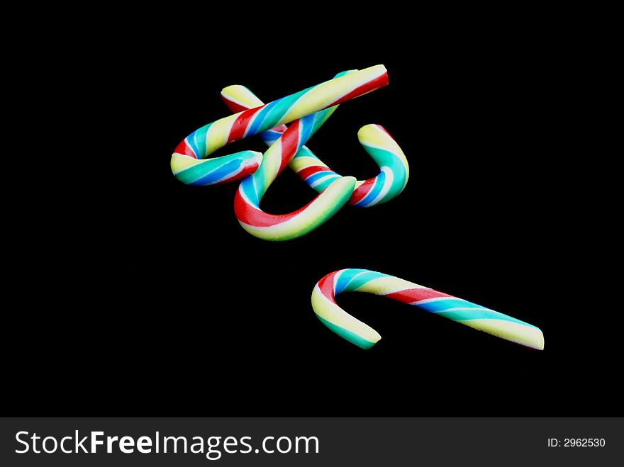 Multicolored candy canes in front of black background. Multicolored candy canes in front of black background.