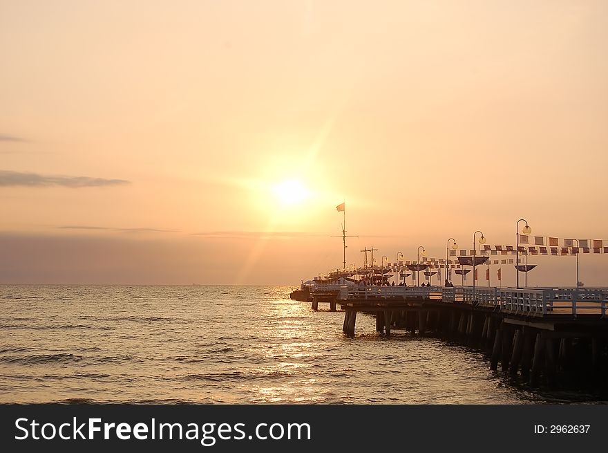 View of sunrise ocean with pier