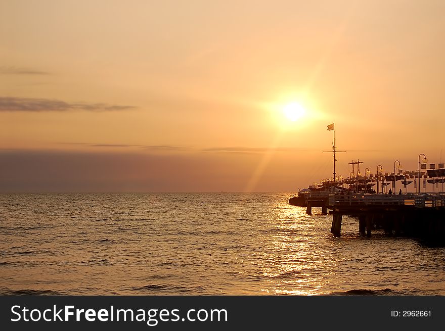 View of sunrise ocean with pier