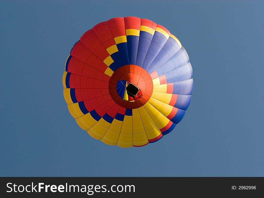 Colourful balloon taking off pictured directly underneath. Colourful balloon taking off pictured directly underneath