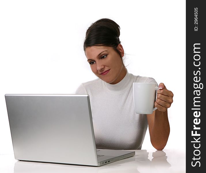 Young woman looks at her laptop computer and drinks her coffee on White Extractable Background. Young woman looks at her laptop computer and drinks her coffee on White Extractable Background