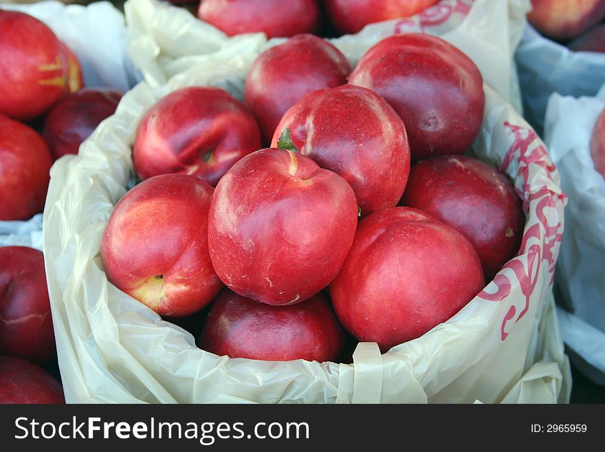 A backet of nectarines for sale at the market