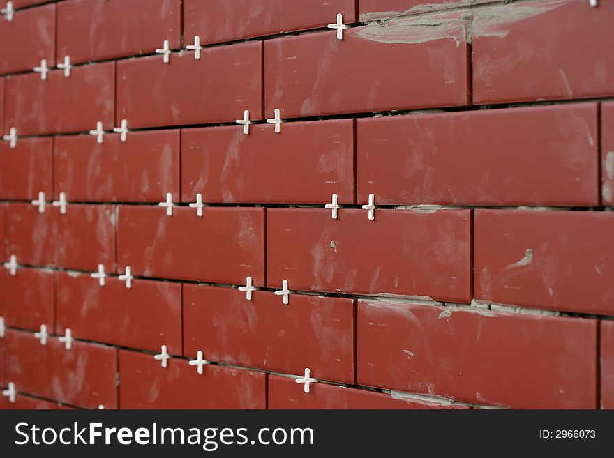 Clinker tiles arranging to wall with pegs.