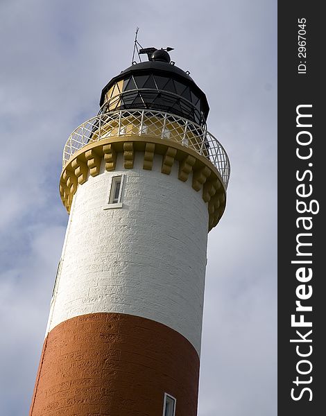 Red and white striped lighthouse on the east coast of Scotland. Red and white striped lighthouse on the east coast of Scotland