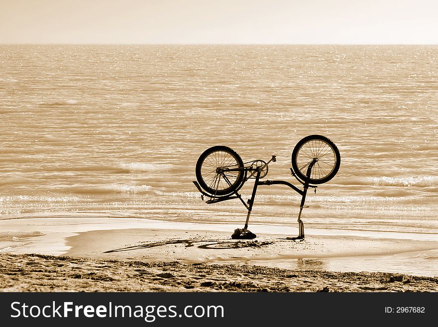 Up-ended bicycle on a beach(toned). Up-ended bicycle on a beach(toned)