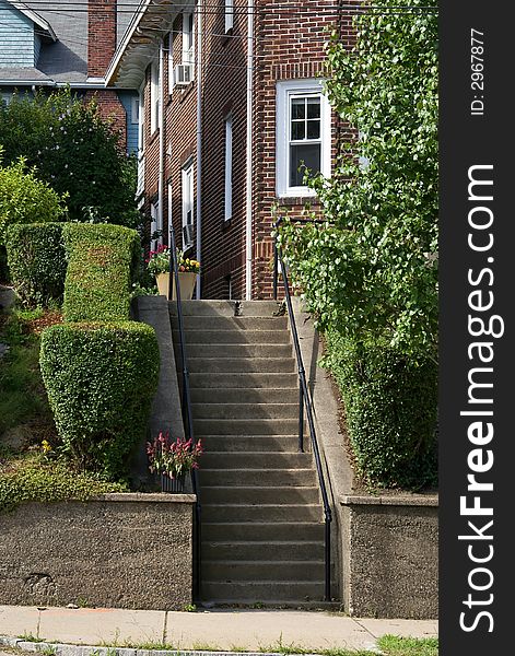 Cement stairs leading up to brick house in suburban community. Cement stairs leading up to brick house in suburban community