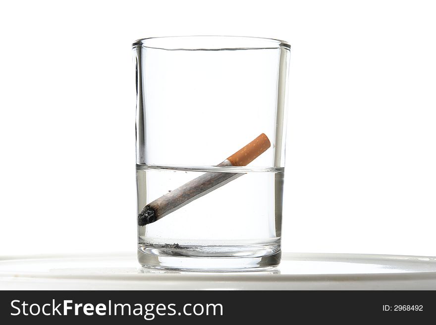 A cigarette extinguished in a glass of water. A cigarette extinguished in a glass of water
