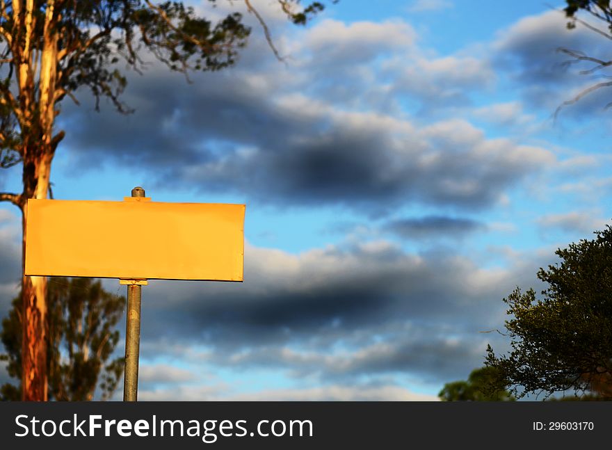 Blank Yellow Sign With Storm Clouds & Huge Gum Tree