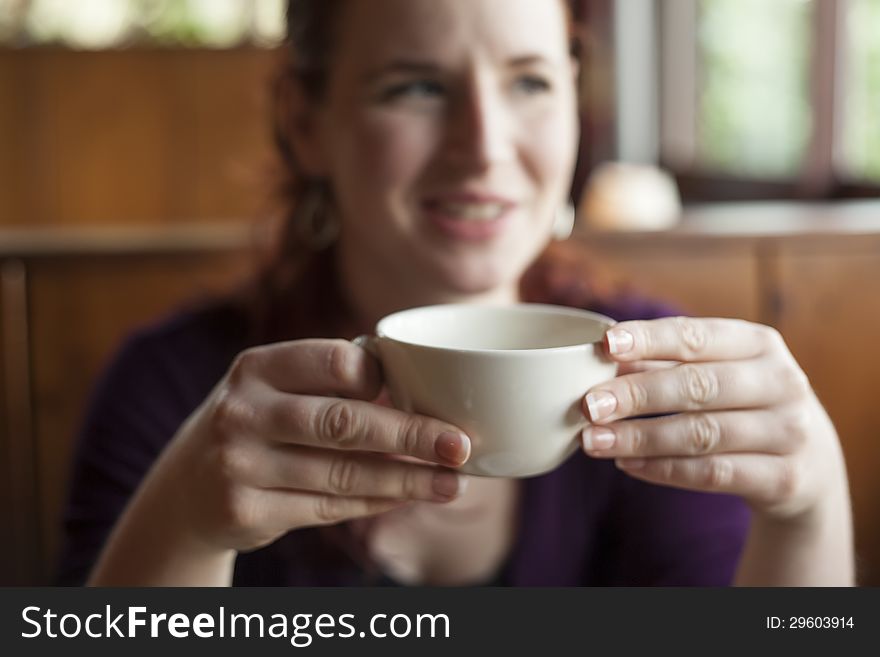 Close up shot of a woman holding her morning cup of coffee.
