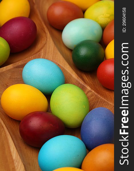 Colorful easter eggs in wooden tablemat.